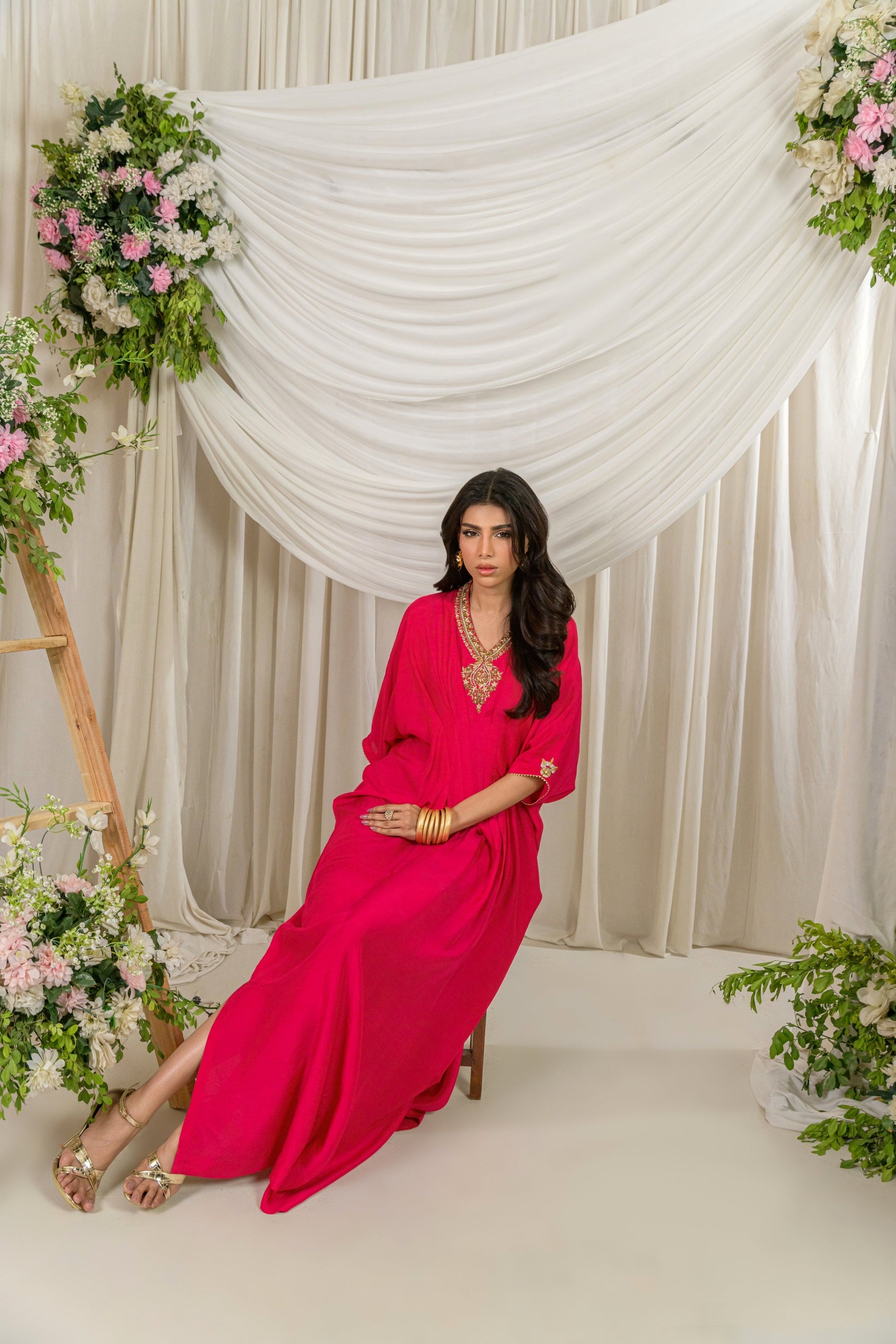 Gulnar - pink Korean raw silk kaftan with gold dabka work sitting pose by Alishba Kashif