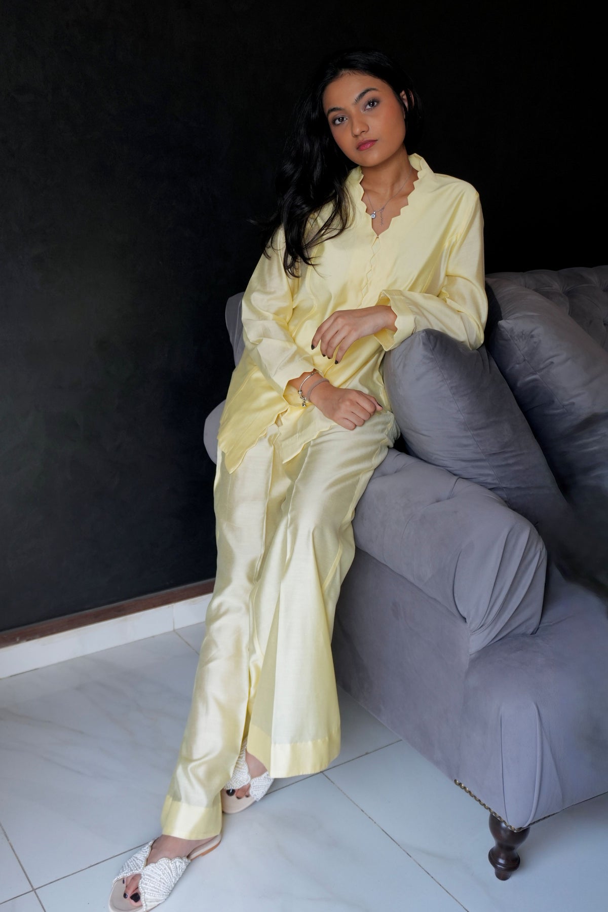 Alisho Buttercream shirt and bootcut pants set worn by a model seated on sofa indoors