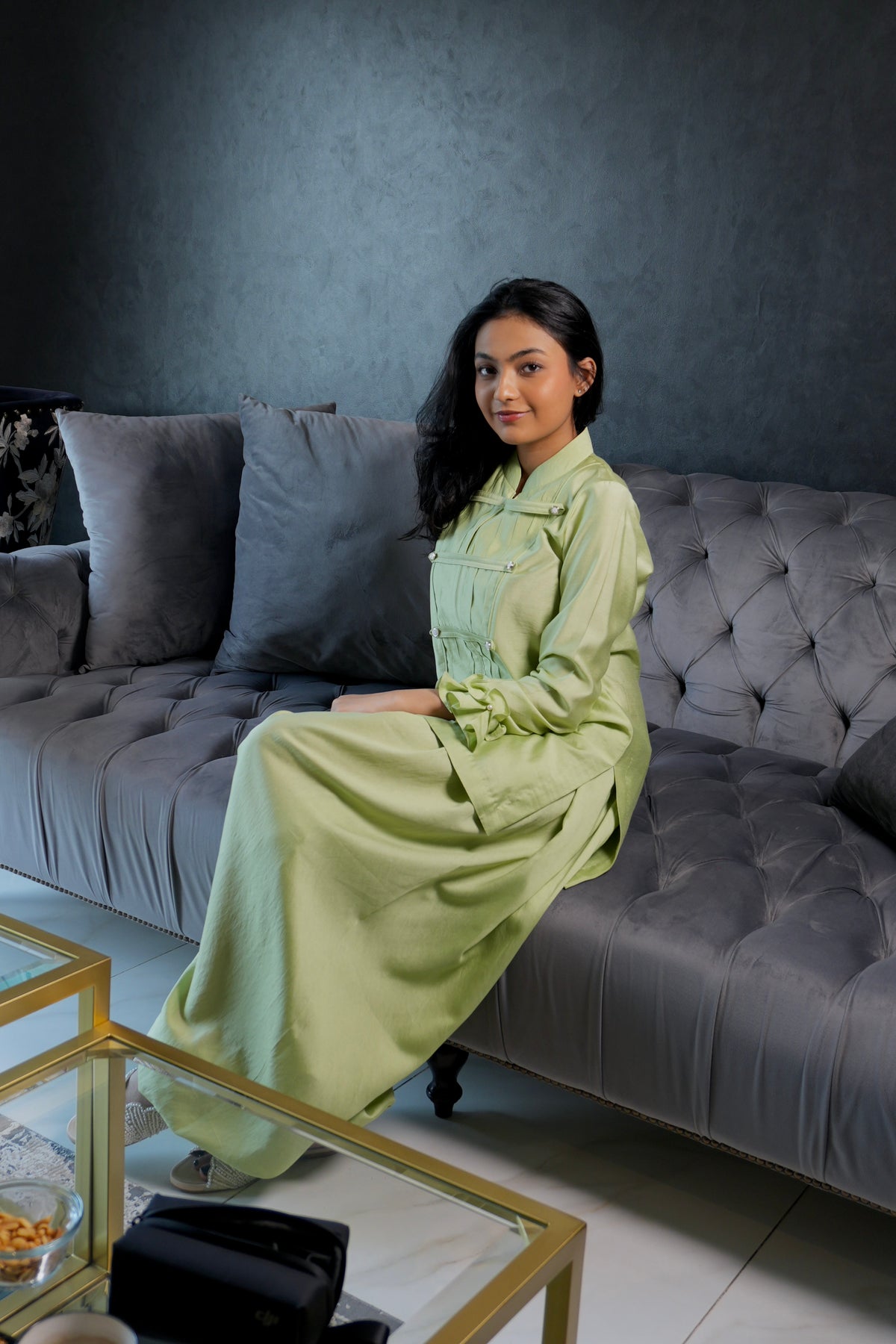 Alisho Matcha Mood matcha green Mandarin-collar top and balloon pants worn by a model seated on a sofa