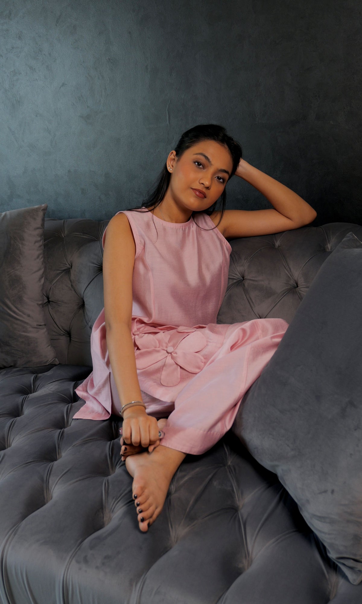 Alisho Petal Pop soft pink sleeveless top and bootcut pants worn by a model seated on sofa