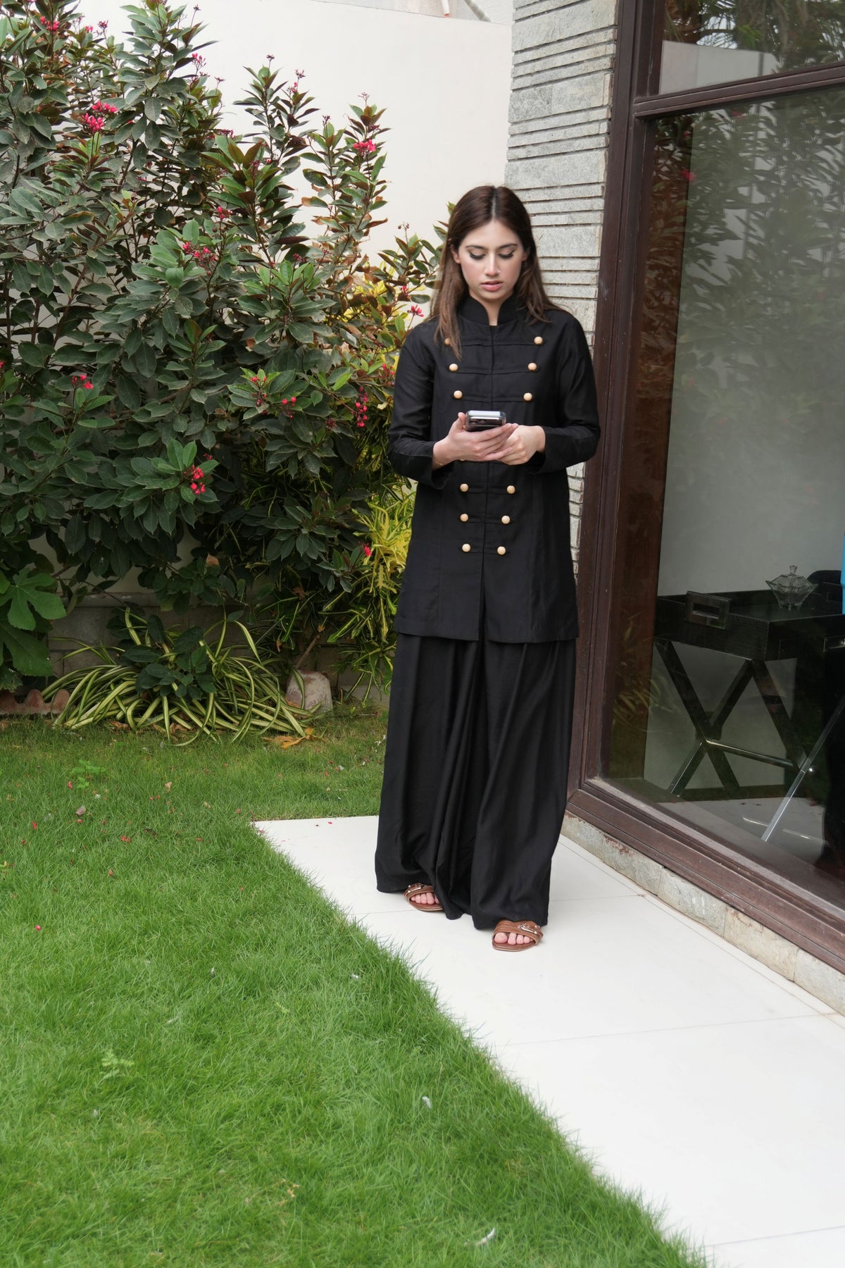 Alisho Power Play black Mandarin collar top and wide leg pants worn by a model outdoors with her phone