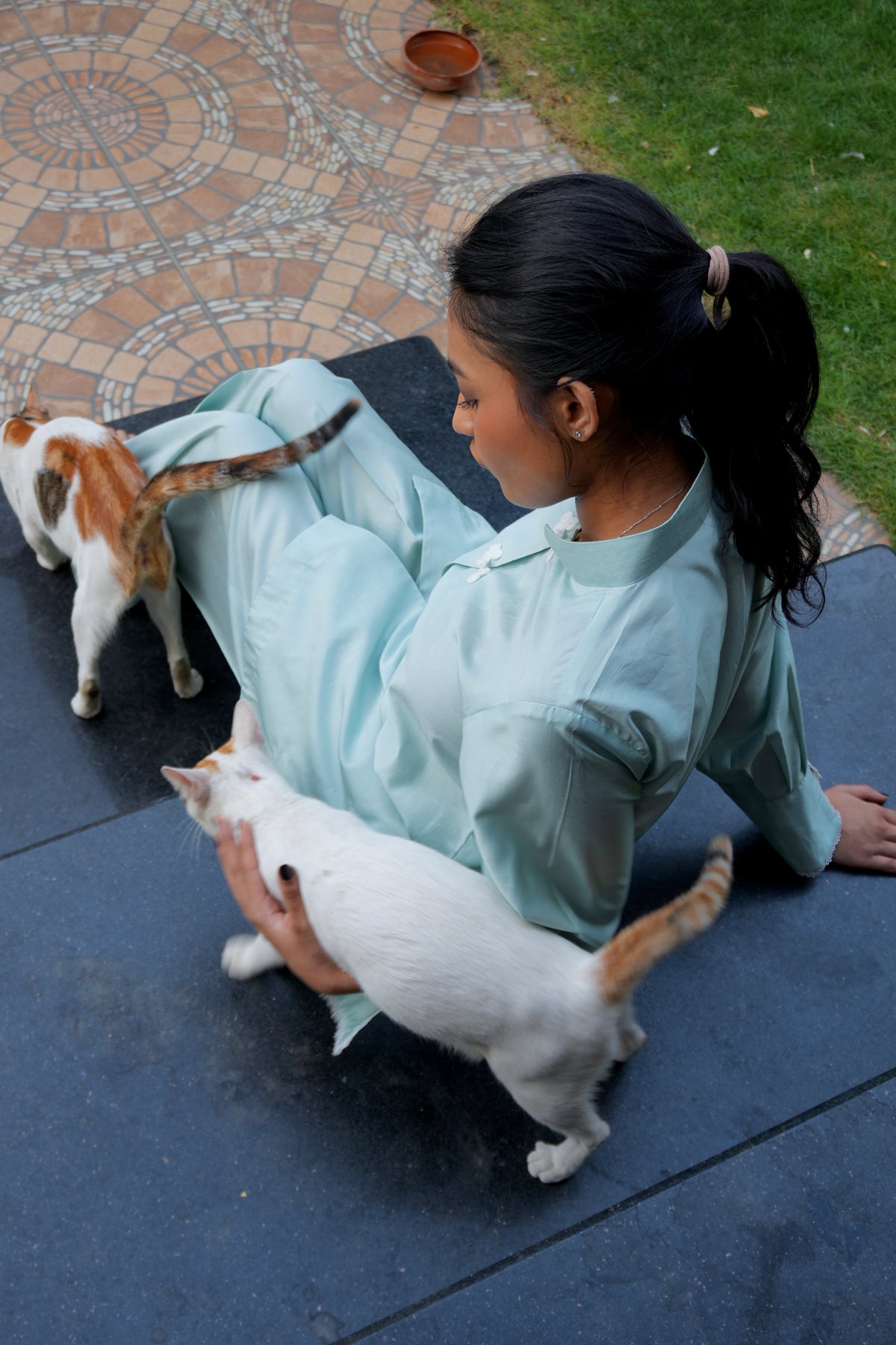 Alisho Soft Launch light blue green shirt and bootcut pants worn by a model with cats