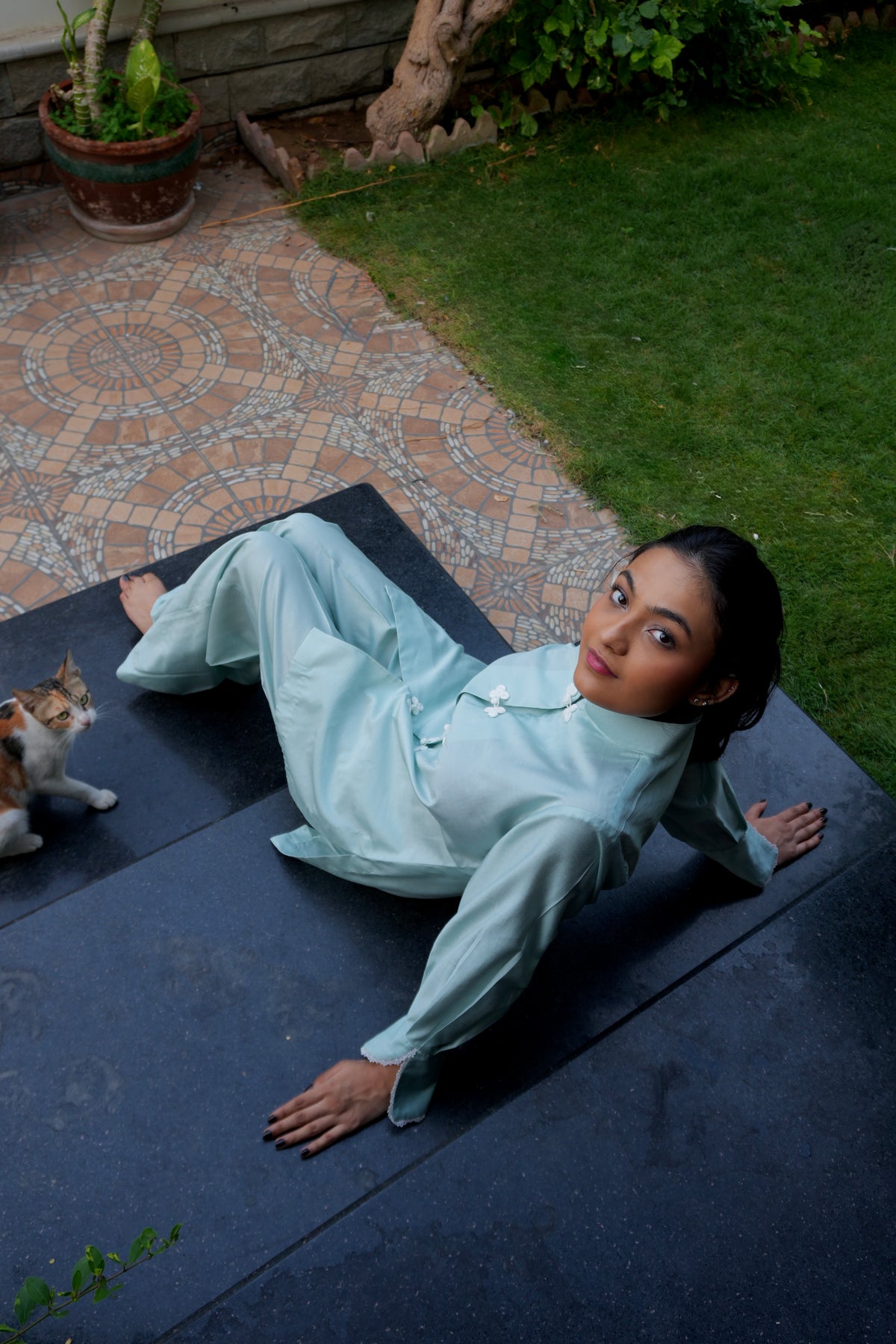 Alisho Soft Launch light blue green shirt and bootcut pants worn by a model outdoors with a cat