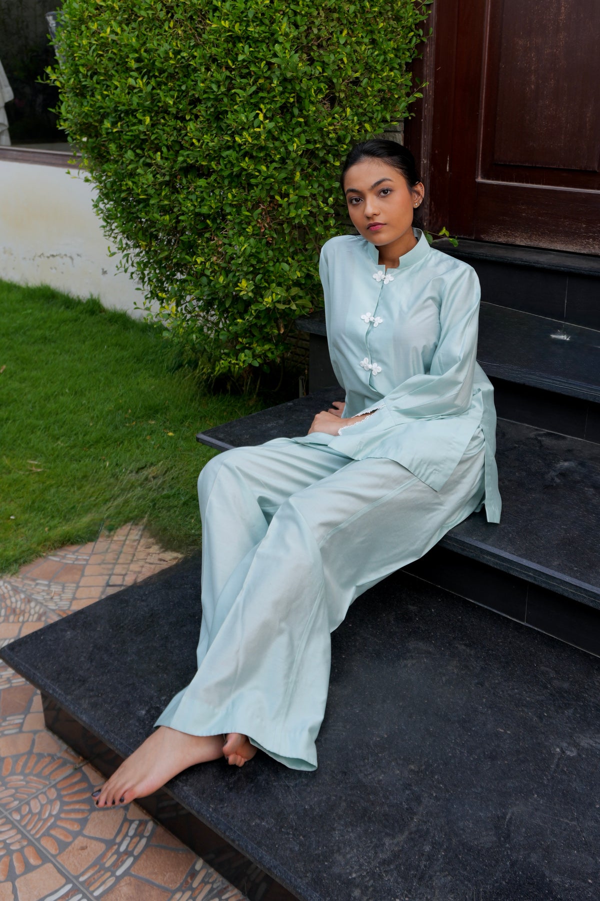 Alisho Soft Launch light blue green shirt and bootcut pants worn by a model outdoors